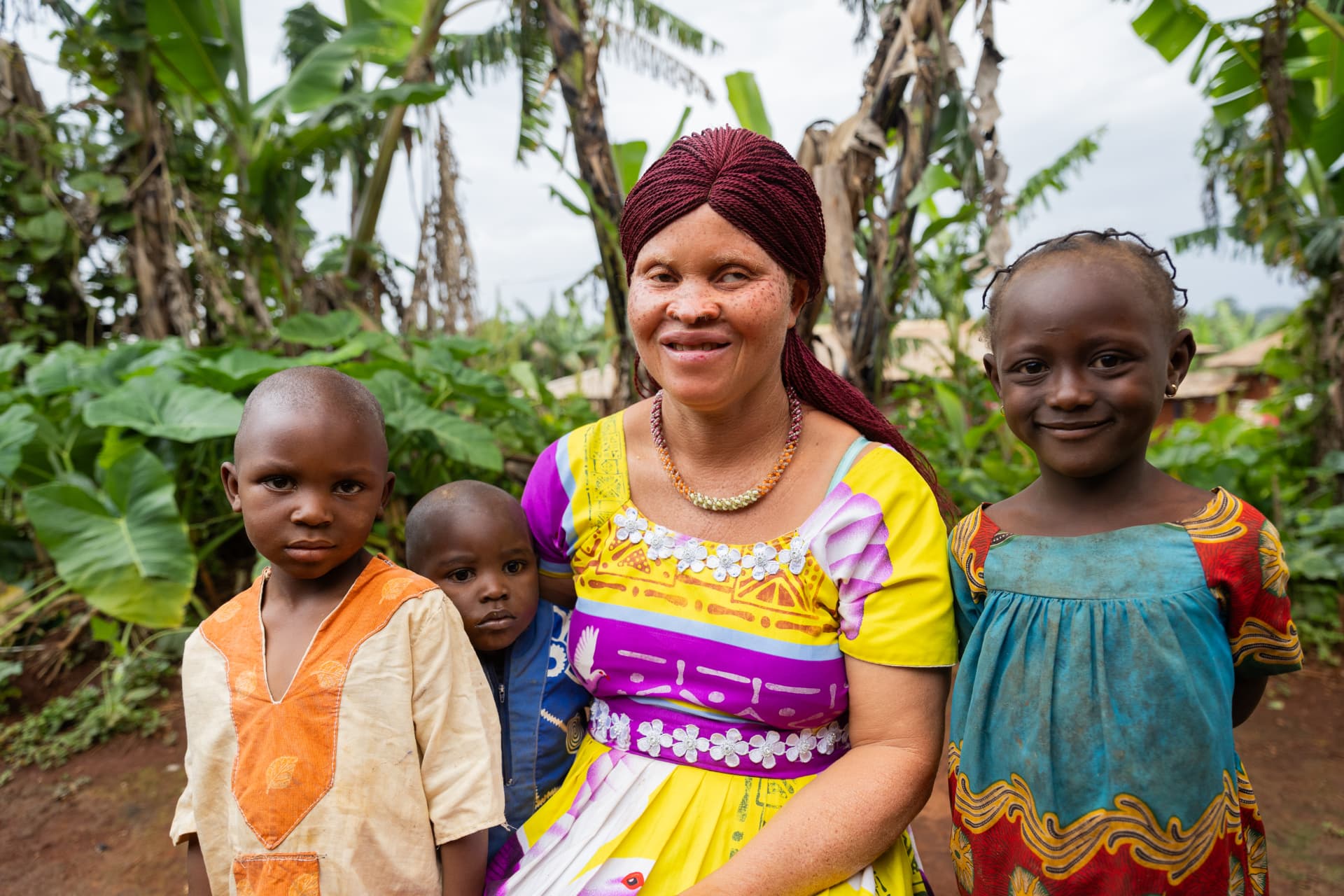 A mother sitting in her garden with her three children